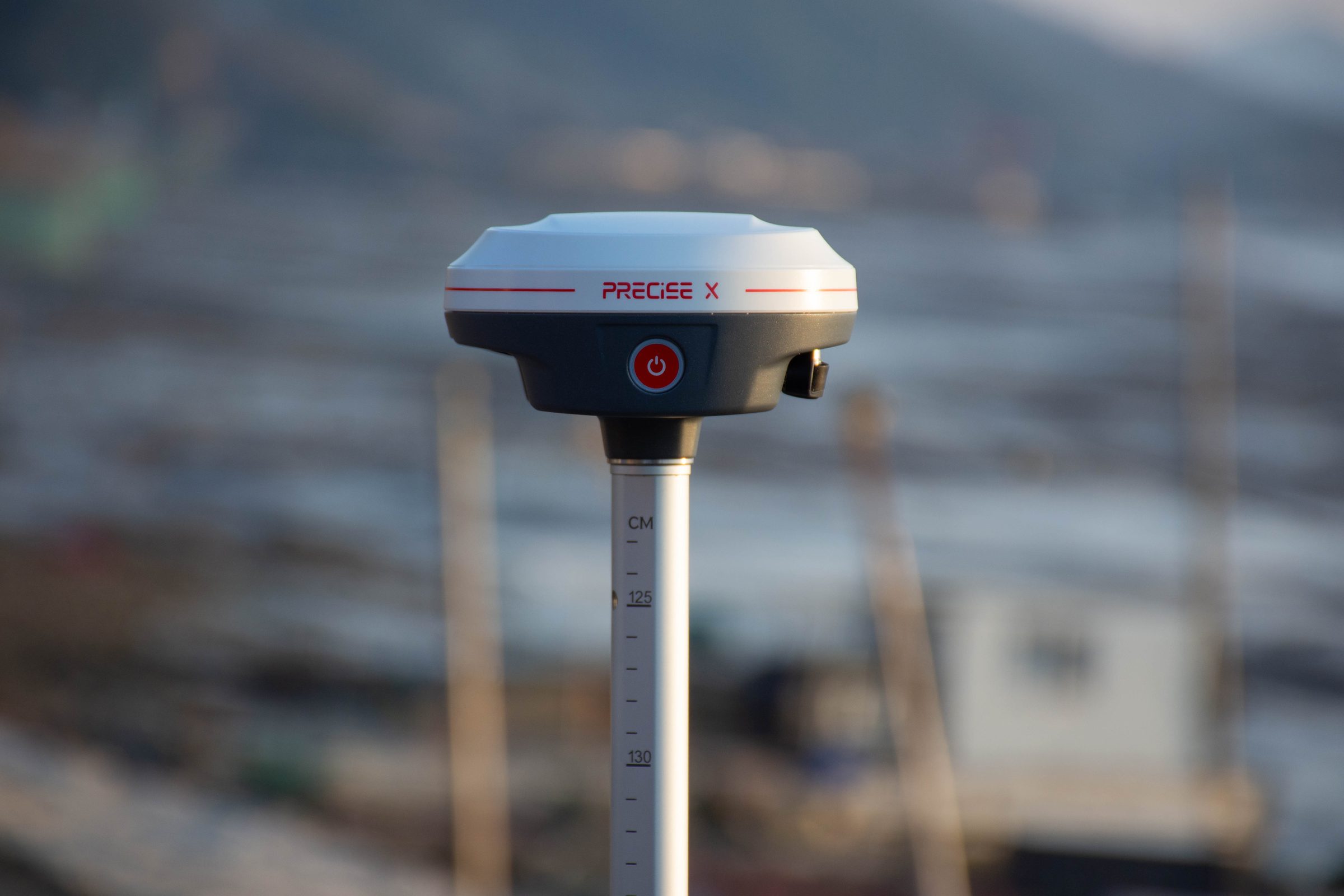 PRECISE X mounted on a survey pole outdoors at golden hour